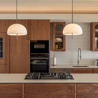 Your gourmet kitchen awaits with warm wood cabinetry, modern appliances, and elegant pendant lighting—perfect for creating memorable meals.