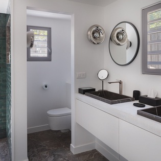 Step into your stylish ensuite with sleek double vanities, elegant black marble sinks, and a private toilet alcove—perfect for your morning routine.