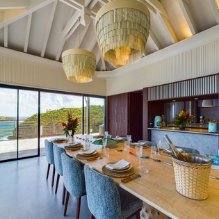 Your elegant dining space features stunning ocean views through floor-to-ceiling windows, perfect for memorable meals with loved ones.