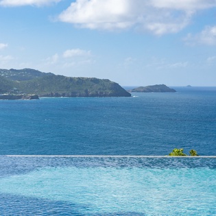 Stunning infinity pool paradise where crystal waters meet endless ocean views and lush tropical islands create your perfect backdrop.