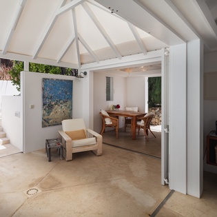 Relax in your airy living space with vaulted ceilings and flowing connections to the dining area, where artistic touches and bright, open doors welcome you into effortless island living.