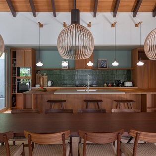 Gather around this stunning open kitchen with warm wood details, designer pendant lights, and an inviting island perfect for your culinary adventures.