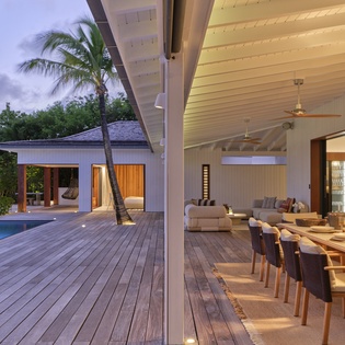 This stunning tropical villa features a private pool, expansive wooden deck, and seamless indoor-outdoor living spaces perfect for relaxation and entertaining.