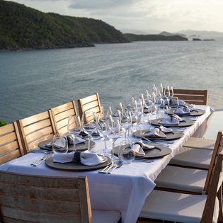 Elegant dining awaits with stunning ocean views and pristine table settings on your private terrace.