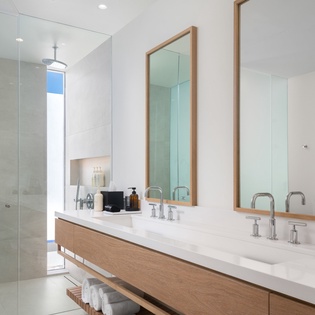 Step into your spa-like bathroom featuring dual vanities, rainfall shower, and warm wood accents for your perfect morning routine.