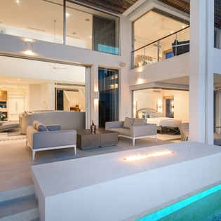 Relax in this stunning open-plan living space where modern luxury meets comfort, featuring soaring ceilings and elegant furnishings.