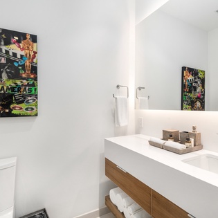 Refresh in your stylish bathroom featuring modern fixtures, curated artwork, and luxurious amenities for your comfort.