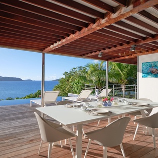Stunning covered terrace showcasing breathtaking ocean views where you'll savor meals while watching azure waters stretch to distant mountains.