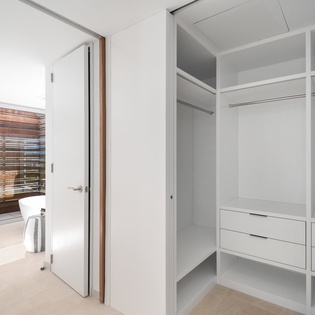 Your spacious walk-in closet offers organized storage with hanging rods, shelves, and built-in drawers to keep your belongings perfectly arranged.