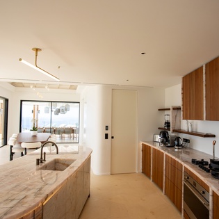 Your gourmet kitchen features marble countertops, premium appliances, and stunning water views to inspire memorable meals.