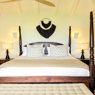 Sink into crisp linens on your elegant four-poster bed beneath soaring cathedral ceilings, where island-inspired décor and warm ambient lighting create the perfect retreat after days exploring paradise.