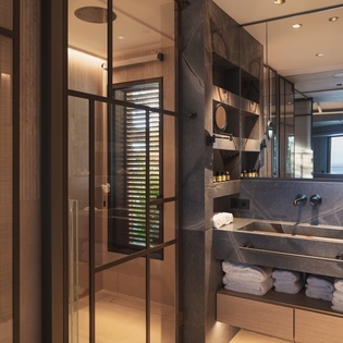 Indulge in your sleek ensuite with rainfall shower, marble vanity, and ocean glimpses through modern shutters.
