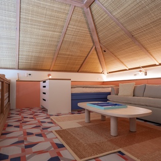 Relax in your unique loft space with vaulted bamboo ceilings, cozy seating, and vibrant geometric floors creating a tropical hideaway feeling.