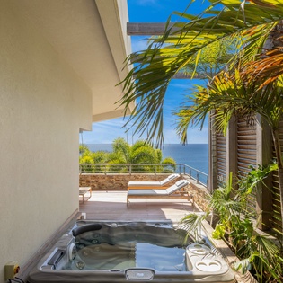 Soak in your private hot tub while gazing at endless ocean views and swaying palms—pure tropical paradise awaits you.
