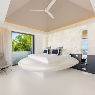 Relax in your sleek modern bedroom with ambient lighting, private balcony access, and tropical garden views.