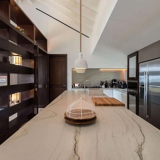 Picture yourself preparing meals at this stunning marble-topped island, surrounded by sleek modern appliances and warm wood accents. The soaring ceilings and thoughtful design create an inspiring culinary space where you'll love cooking during your stay.