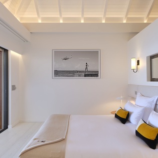 Sink into crisp linens and gaze at curated artwork in your serene retreat. Step through sliding doors to your private outdoor space, where tranquil moments await.