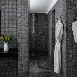Indulge in your private spa-like bathroom featuring elegant mosaic tiles and plush robes for ultimate relaxation.