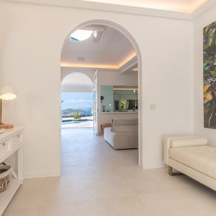 Your bright, elegant living space flows seamlessly through graceful archways, leading to stunning water views that await just beyond.