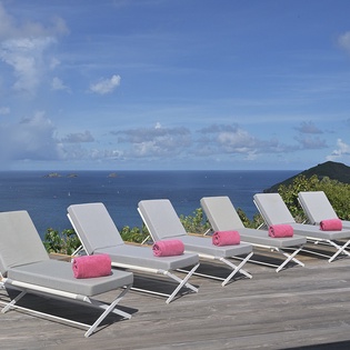 Luxurious deck overlooks endless ocean views with six premium loungers ready for your perfect day of relaxation in paradise.
