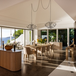 Your elegant open-plan living space flows seamlessly from kitchen to dining, with stunning sea views framing every meal and moment of relaxation.