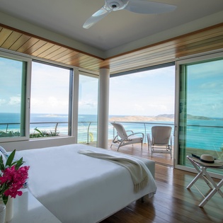 Wake up to stunning ocean views from your bed, with floor-to-ceiling windows framing endless blue waters and private balcony access.