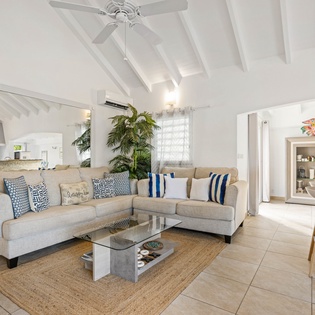 Relax in your bright, airy living room with soaring beamed ceilings, comfortable sectional seating, and tropical touches that create the perfect island escape.
