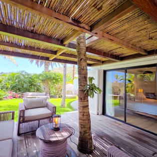 Your private terrace opens to lush gardens where you'll lounge under swaying palms, morning coffee in hand, soaking in tropical breezes. Inside, your serene bedroom awaits through sliding glass doors.