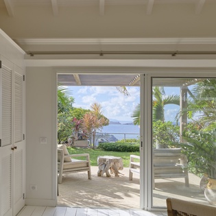 Step through open doors to your private patio, where tropical palms frame sweeping sea views. Relax at your outdoor seating and savor the island breeze and endless blue horizon.