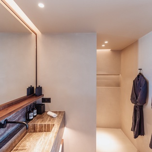 Sink into luxury with your private spa-inspired bathroom, featuring rich wood vanity and plush robes waiting for your arrival.