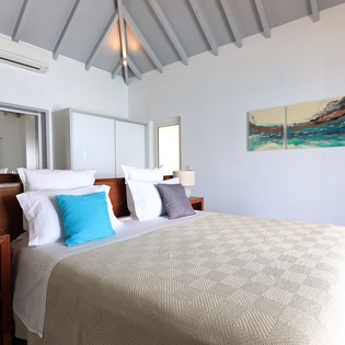 Your airy bedroom features vaulted ceilings, ocean artwork, and comfortable linens for peaceful nights.