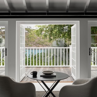 Settle into your private dining nook where morning coffee meets stunning pool and garden views through elegant French doors.