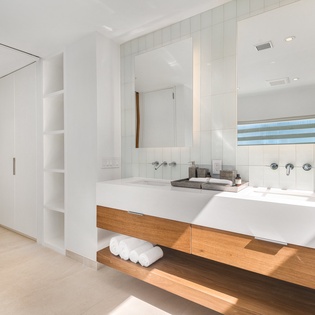 Unwind in your spa-like bathroom with sleek finishes, natural light streaming through the window, and luxurious towels waiting for your arrival.