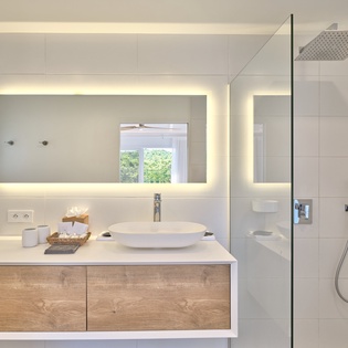 Step into your spa-like sanctuary with modern fixtures, rainfall shower, and warm lighting that creates the perfect retreat.