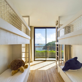 Drift off to sleep in your cozy bunk bed while gazing at stunning ocean views through floor-to-ceiling windows.