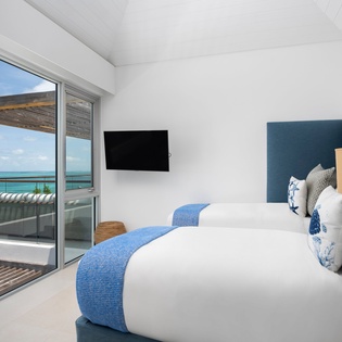 Wake up to stunning ocean views from your luxurious bedroom, where crisp linens and coastal blues create the perfect seaside sanctuary.