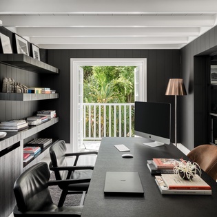 Your sophisticated home office overlooks lush tropical palms, offering the perfect blend of productivity and serenity for remote work.