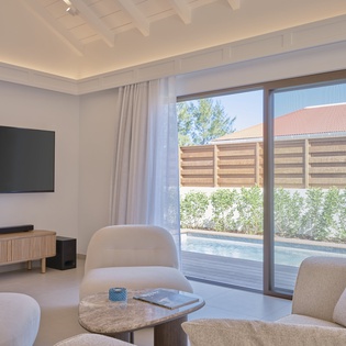 Unwind in your elegant living space with sleek entertainment setup and direct pool access through sliding doors.