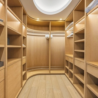Your spacious walk-in closet features custom wood shelving and drawers, offering abundant storage for all your belongings in elegant style.