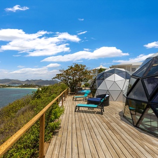 Relax on your private deck with stunning turquoise waters stretching to distant mountains—your perfect seaside sanctuary awaits.
