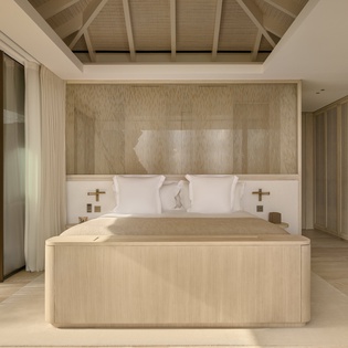 Sink into your private sanctuary with this stunning bedroom featuring warm wood tones, exposed beams, and floor-to-ceiling windows opening to your secluded patio.