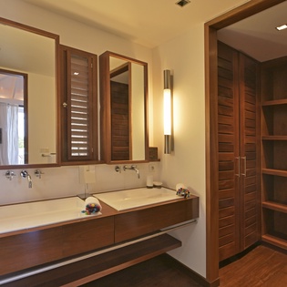 Unwind in your elegant bathroom featuring dual vanities, warm wood accents, and modern lighting that creates the perfect spa-like atmosphere.