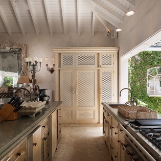 Your gourmet kitchen opens seamlessly to a leafy courtyard, blending elegant cabinetry with timeless vaulted ceilings and artisan details for inspired cooking and entertaining.