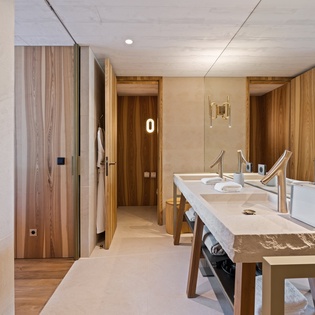 Step into your elegant bathroom featuring warm wood finishes, dual sinks, and luxurious modern amenities for a spa-like experience.