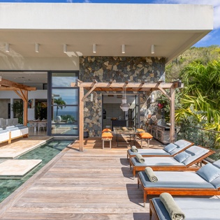 Your private pool deck offers sleek loungers and tropical palm views, perfect for soaking up Caribbean sunshine in complete luxury.