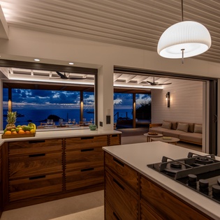 Prepare meals in this stunning open kitchen while savoring breathtaking ocean views through floor-to-ceiling windows.
