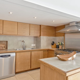 Your fully equipped kitchen awaits with modern appliances, warm wood cabinetry, and island space perfect for cooking memorable meals during your stay.