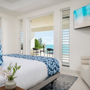 Wake up to stunning turquoise waters through your floor-to-ceiling windows. The fresh coastal breeze flows through louvered shutters into your serene sanctuary.