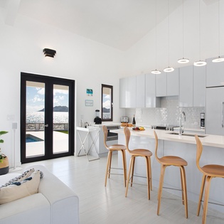 Picture yourself preparing meals in this bright, modern kitchen while enjoying stunning ocean views. The space flows seamlessly into a sun-filled living area, with a breezy balcony just steps away.