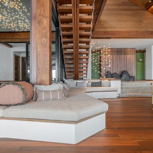Sink into luxury on this stunning sunken sofa beneath twinkling ceiling lights, where modern design meets ultimate comfort in your spacious retreat.